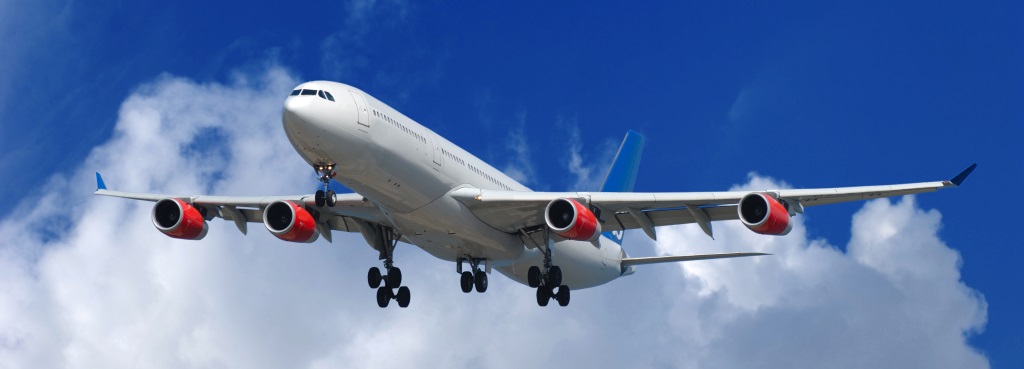 Big airliner on blue and cloudy sky.